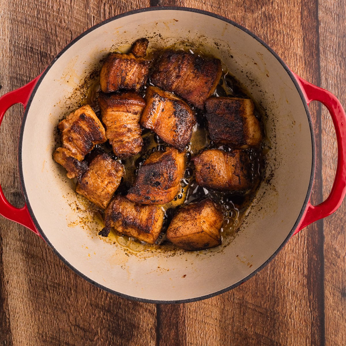 Searing pork belly cubes to a mahogany crust in the Dutch oven