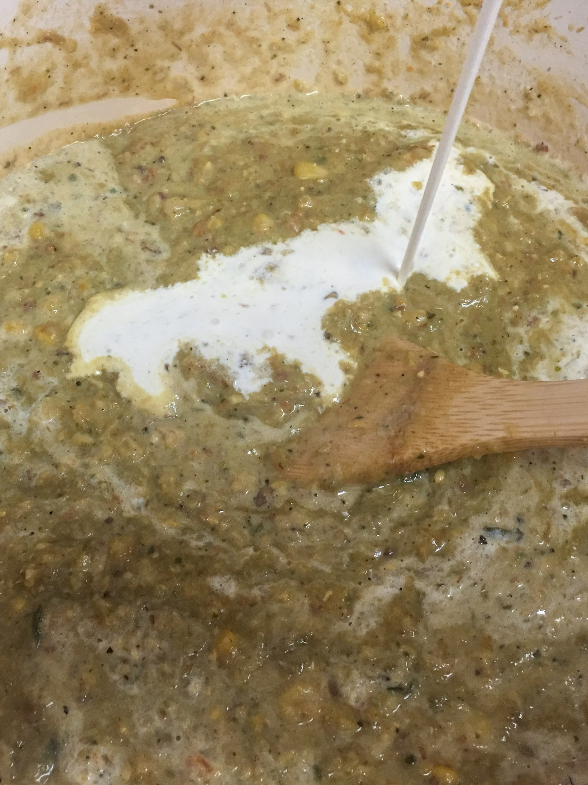 Heavy cream being stirred into the poblano corn chowder.