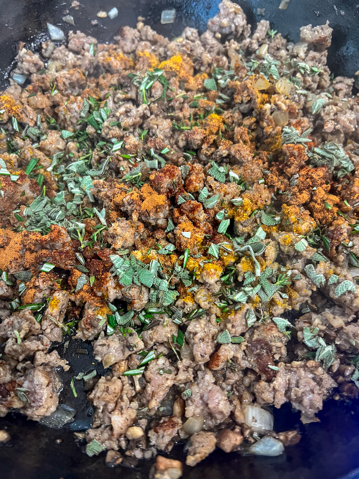 Herbs and warm spices stirred into the cooked sausage filling.