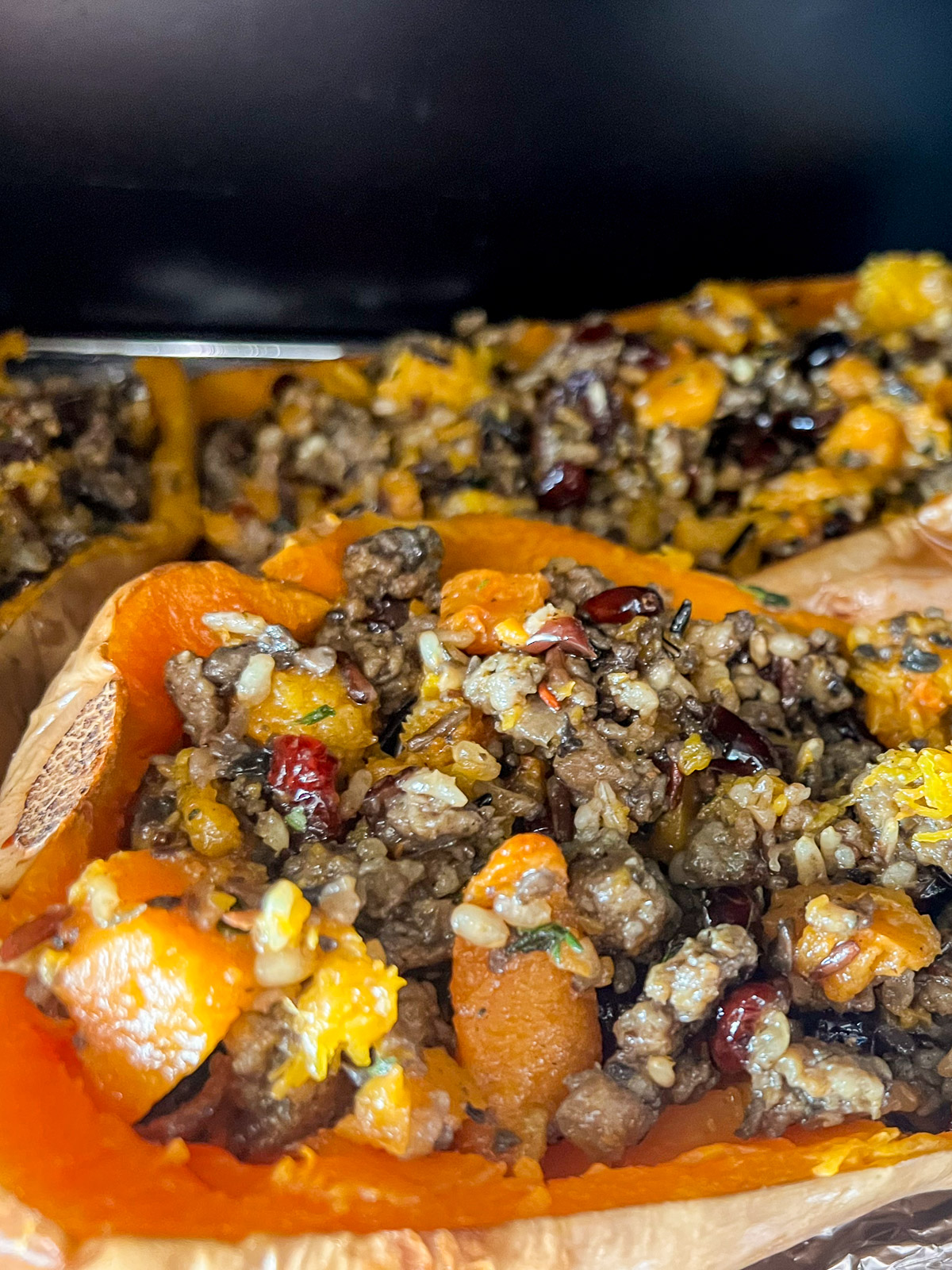Stuffed butternut squash halves going into the oven for the final bake.