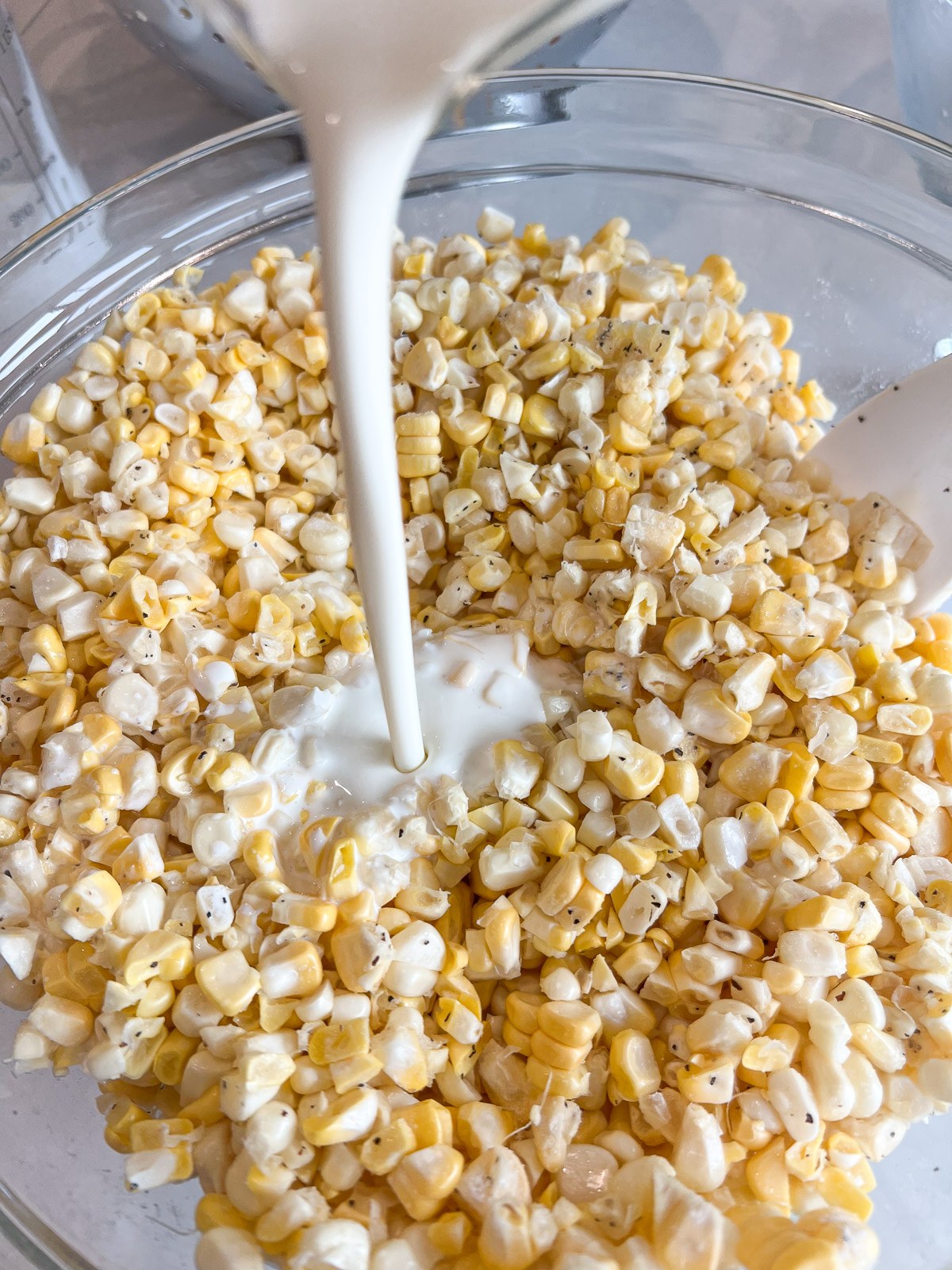 Heavy cream poured over the seasoned corn kernels.