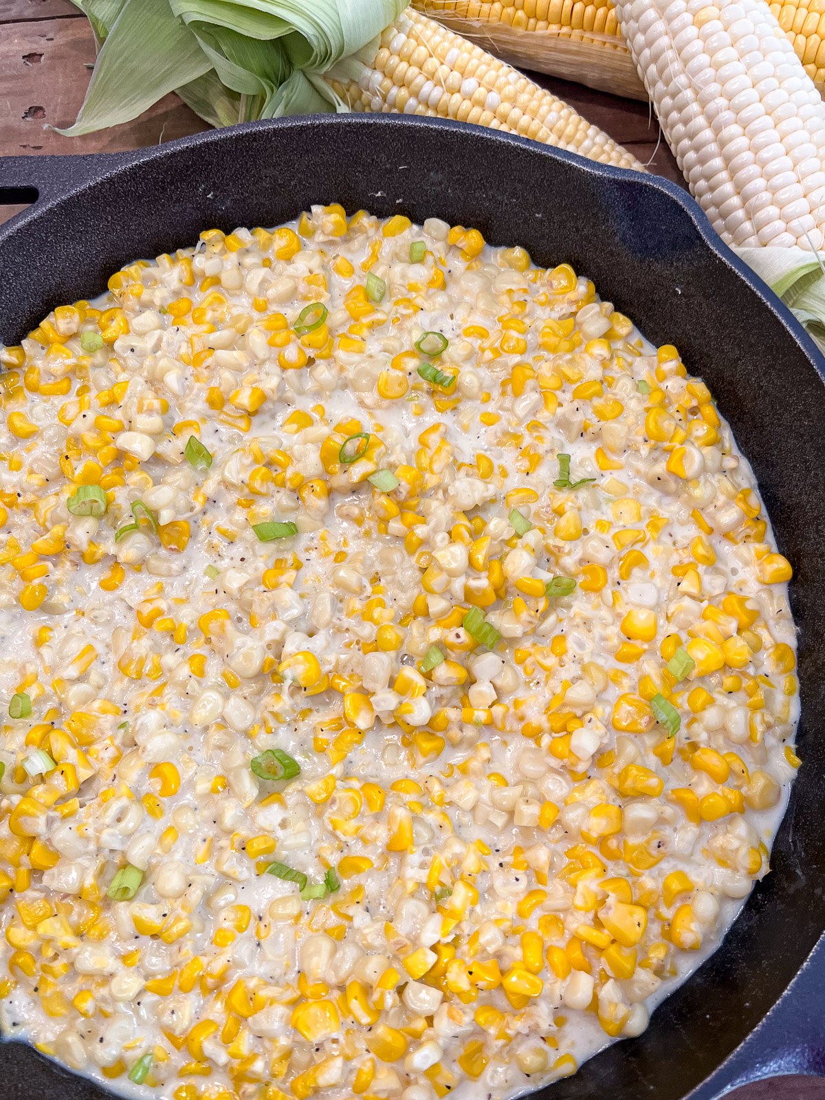 Southern creamed corn simmering in a cast iron skillet.