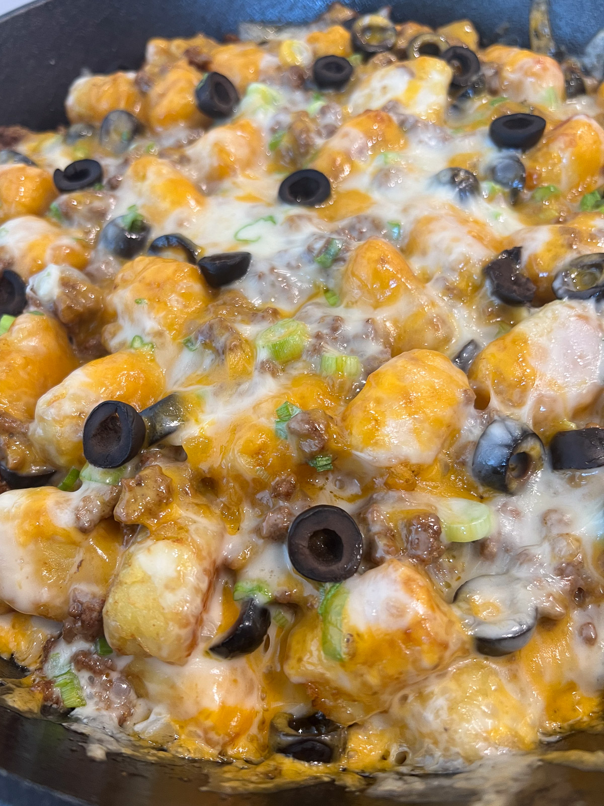 Final layer of melted cheese baked over tater tot nachos.