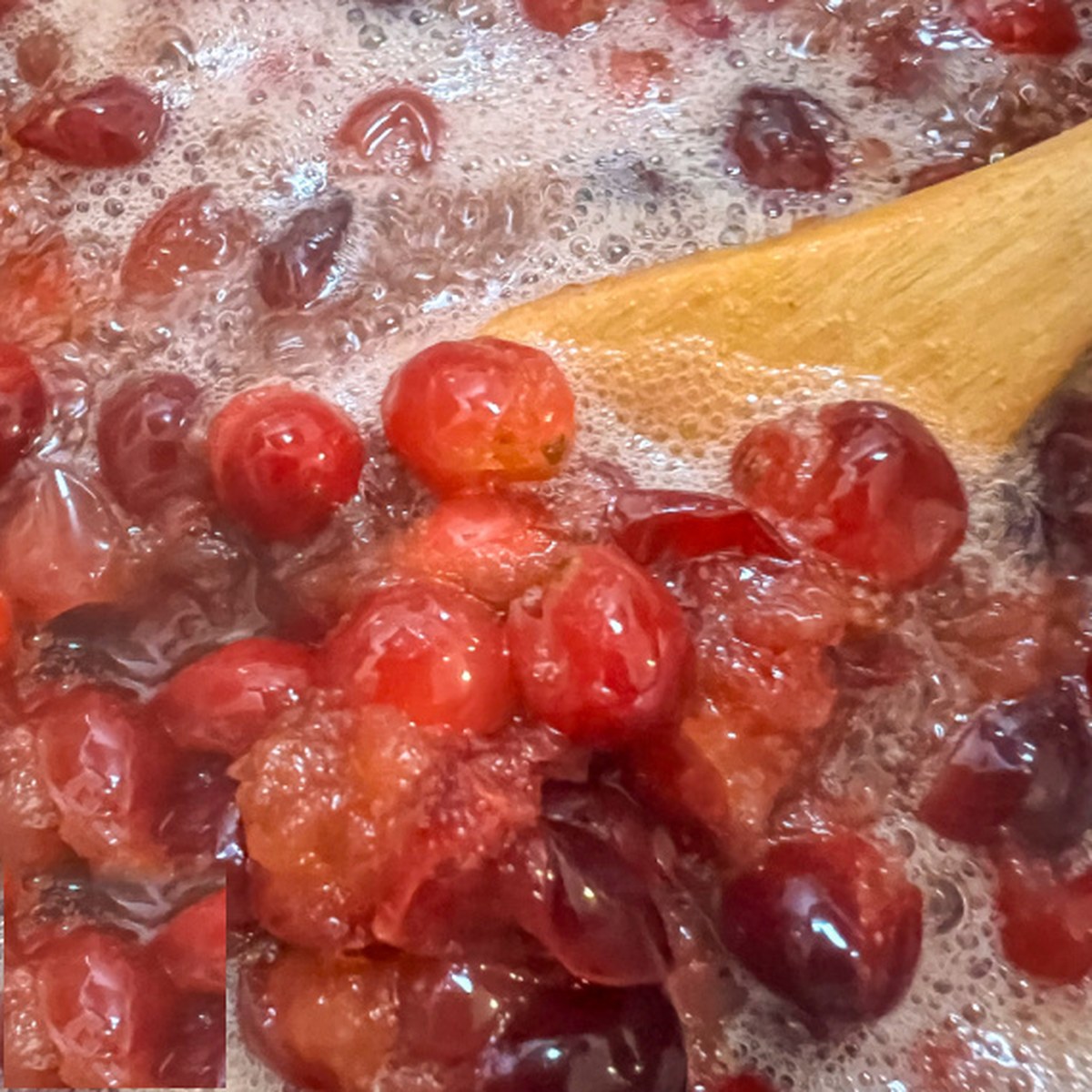 Cranberries beginning to pop and break down as the sauce cooks.