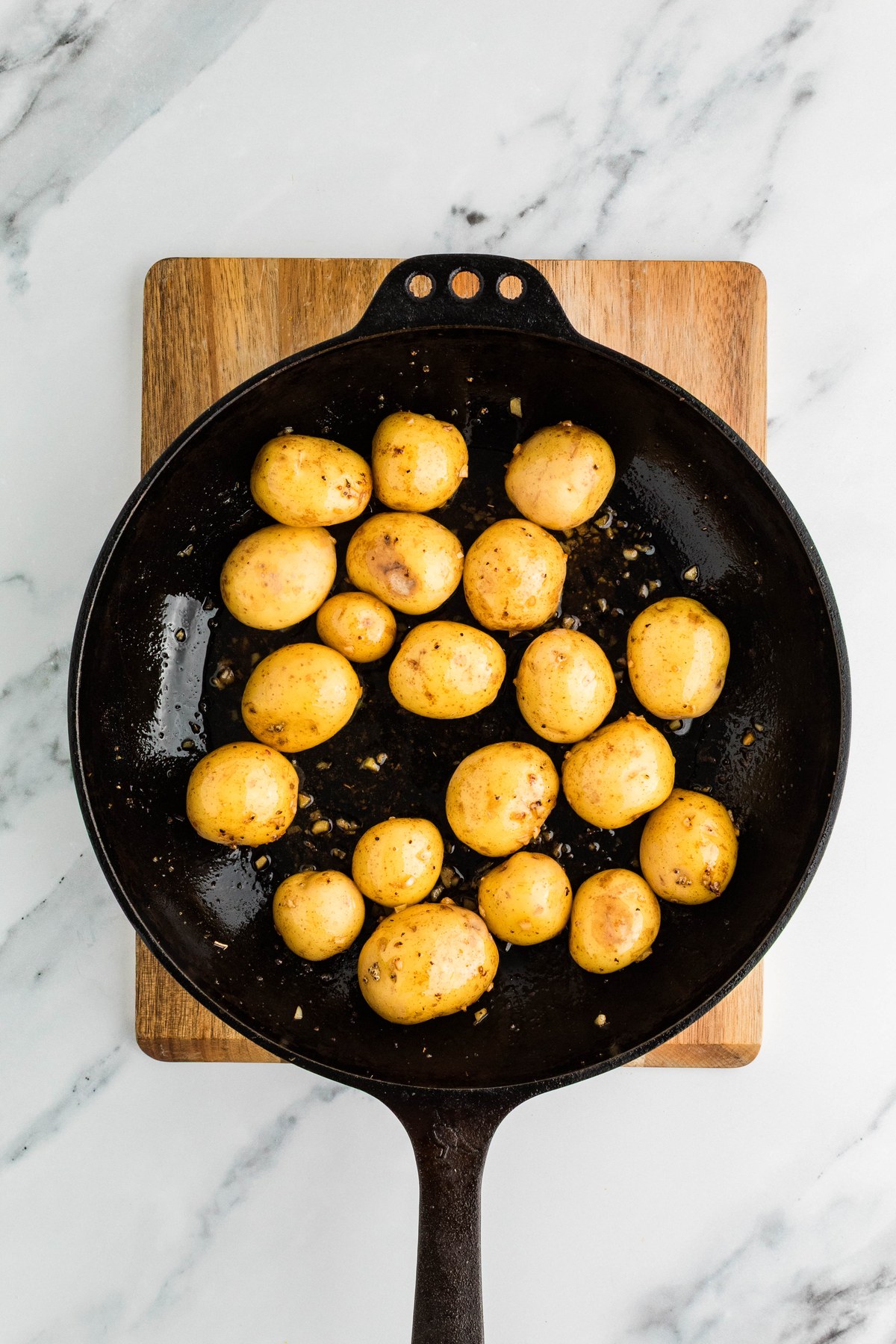 Baby Yukon gold potatoes tossed in lemon butter sauce in a cast iron skillet