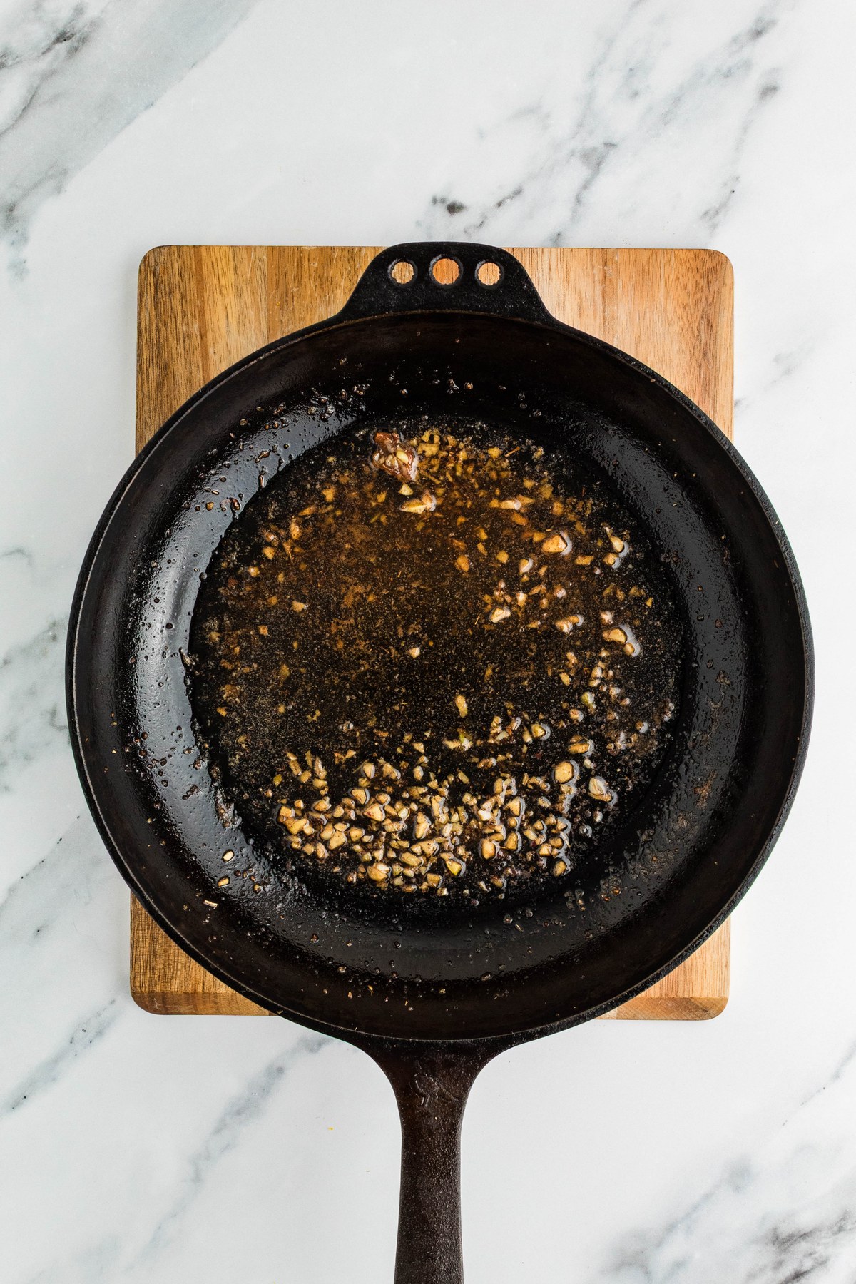 Butter lemon and garlic sauce melting in a cast iron skillet