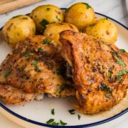 Plated Greek lemon chicken thigh with baby Yukon gold potatoes and parsley