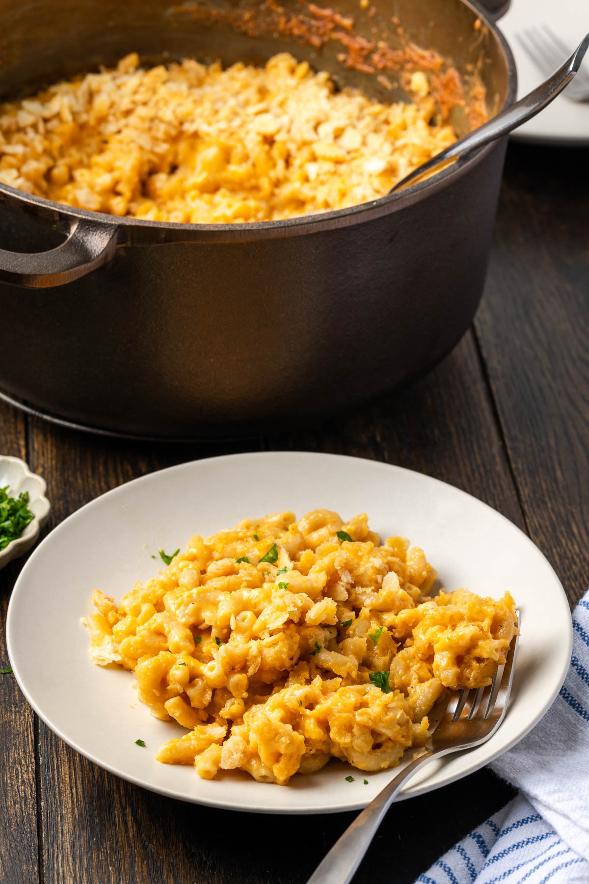 Dutch oven mac and cheese plated with the cast iron dutch oven in the background