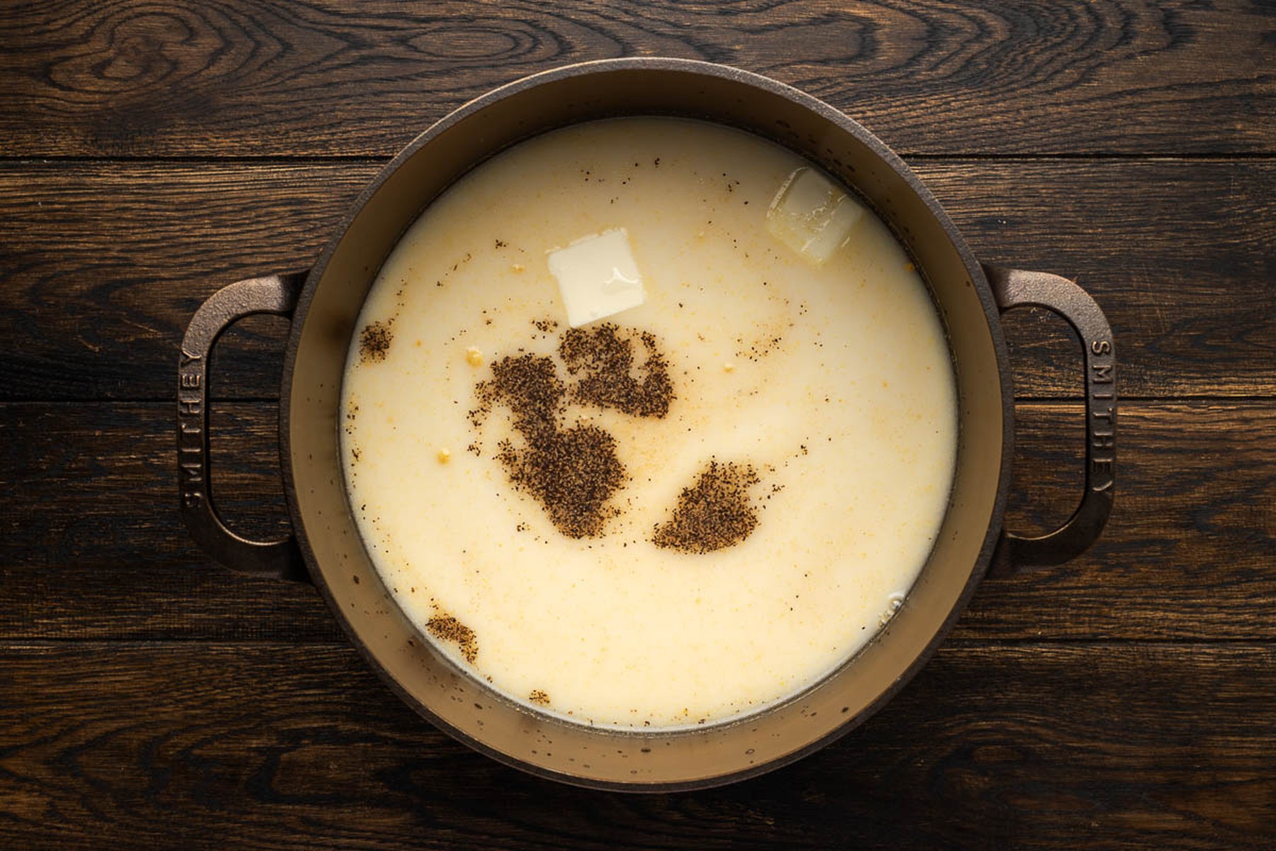 Simmering liquid with butter evaporated milk and seasonings in a cast iron pot