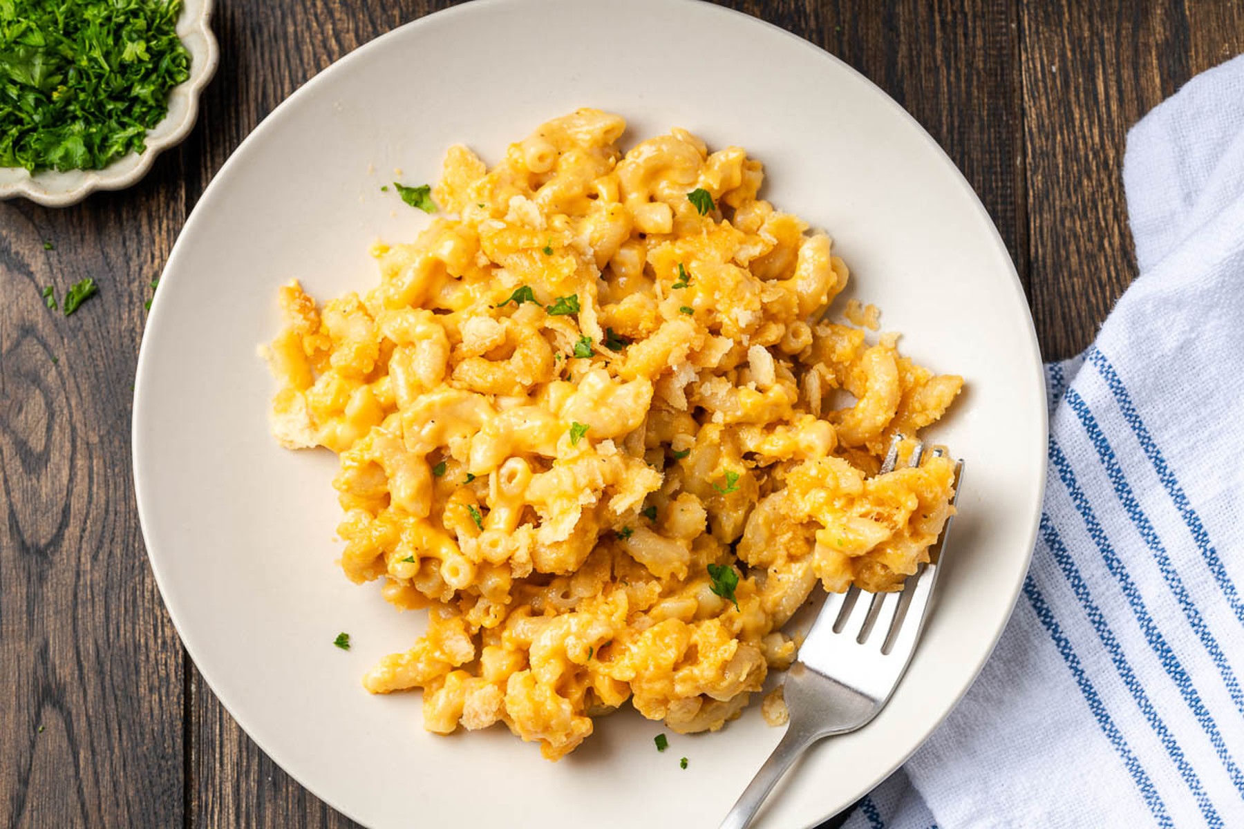 Dutch oven mac and cheese served on a white plate with parsley garnish