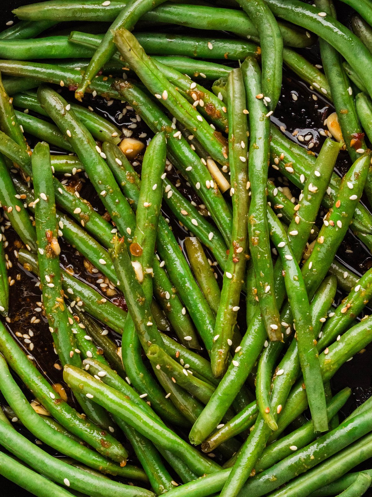 Close up of Asian green beans coated in glossy soy garlic sauce