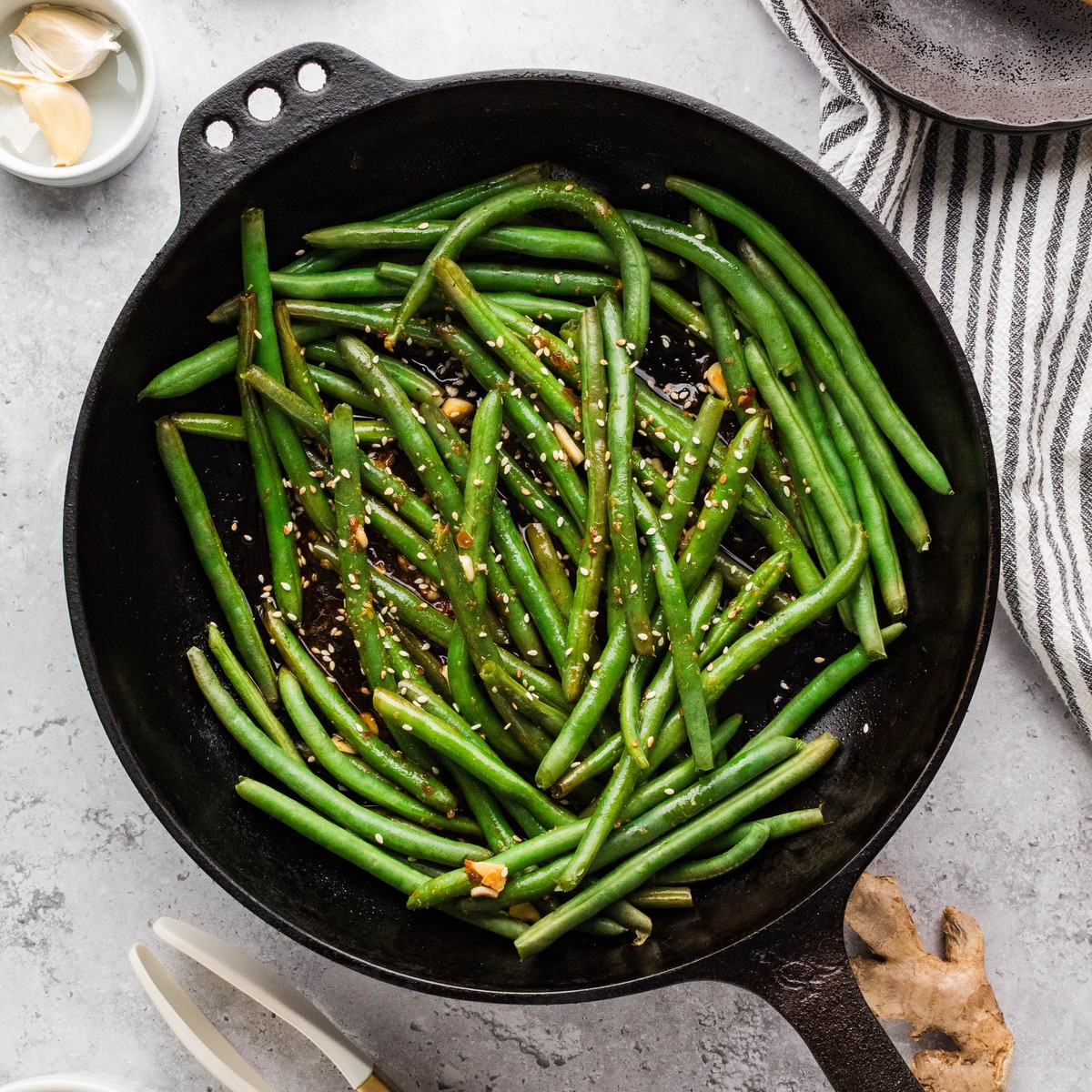 Asian green beans tossed in soy garlic sauce in a cast iron skillet