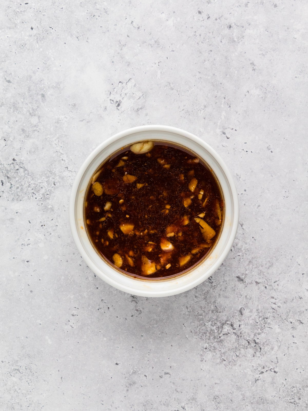 Whisked Asian green bean sauce with garlic and ginger in a white bowl