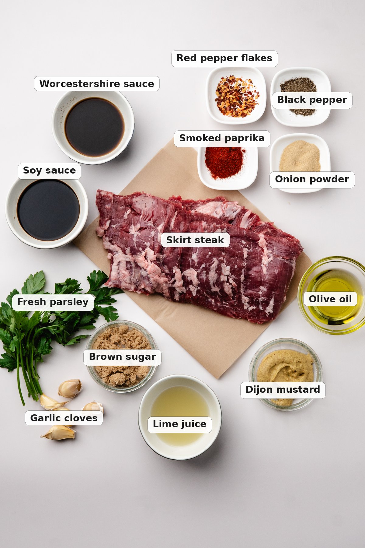 Labeled ingredients for steak marinade including soy sauce, Worcestershire sauce, olive oil, brown sugar, Dijon mustard, garlic and lime juice