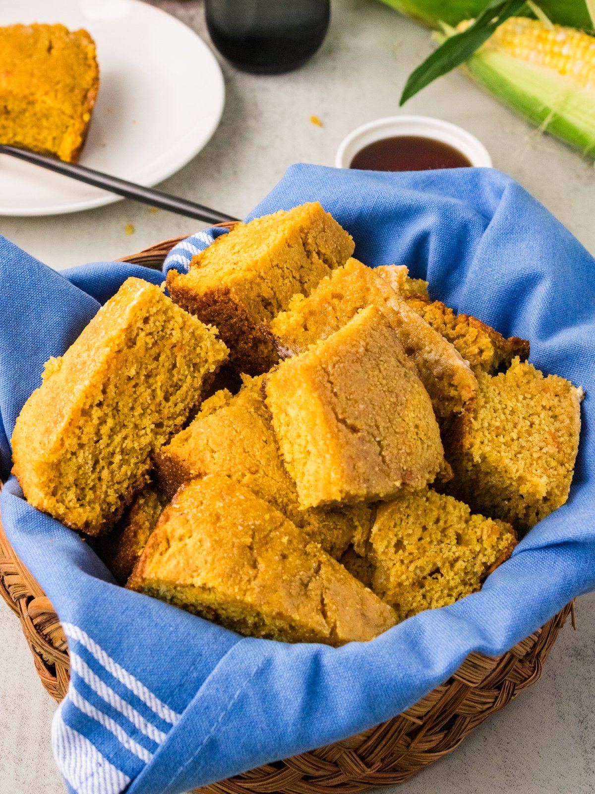 Cubed sweet potato cornbread in a napkin lined basket