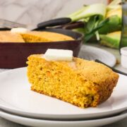 Sweet potato cornbread slices plated on white plates with butter