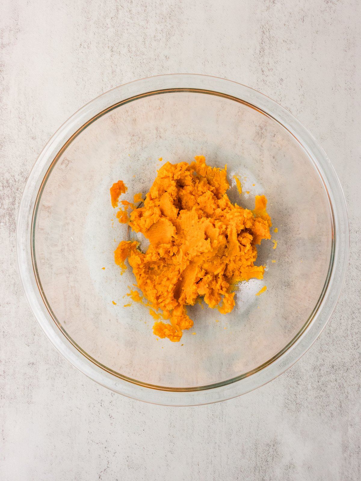 Mashed sweet potato puree in a glass bowl for sweet potato cornbread