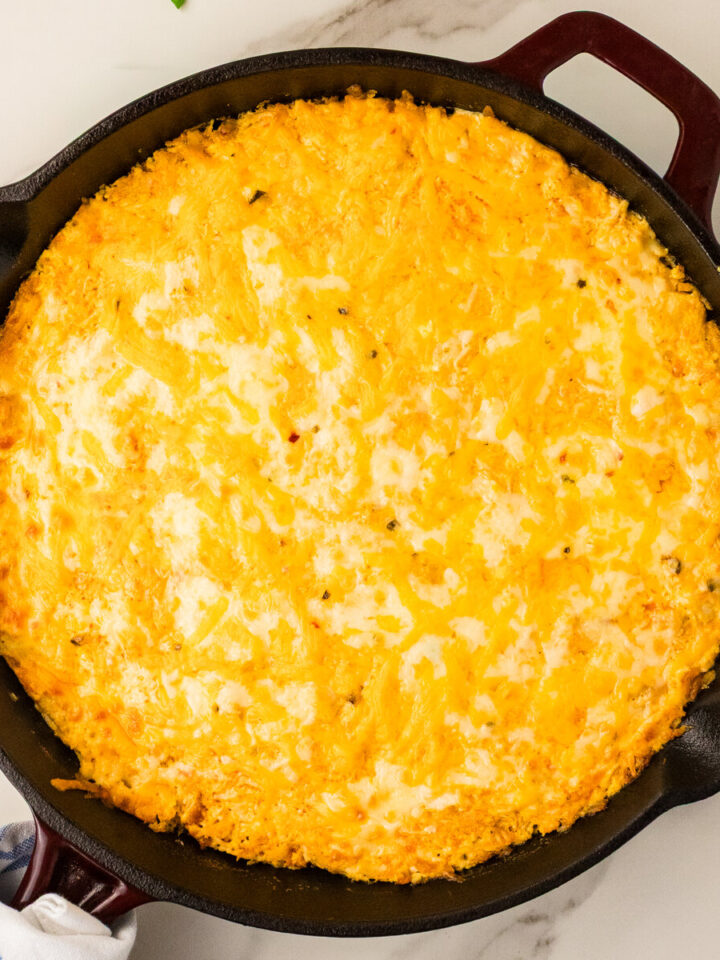 Cast iron buffalo chicken dip baked golden in a skillet