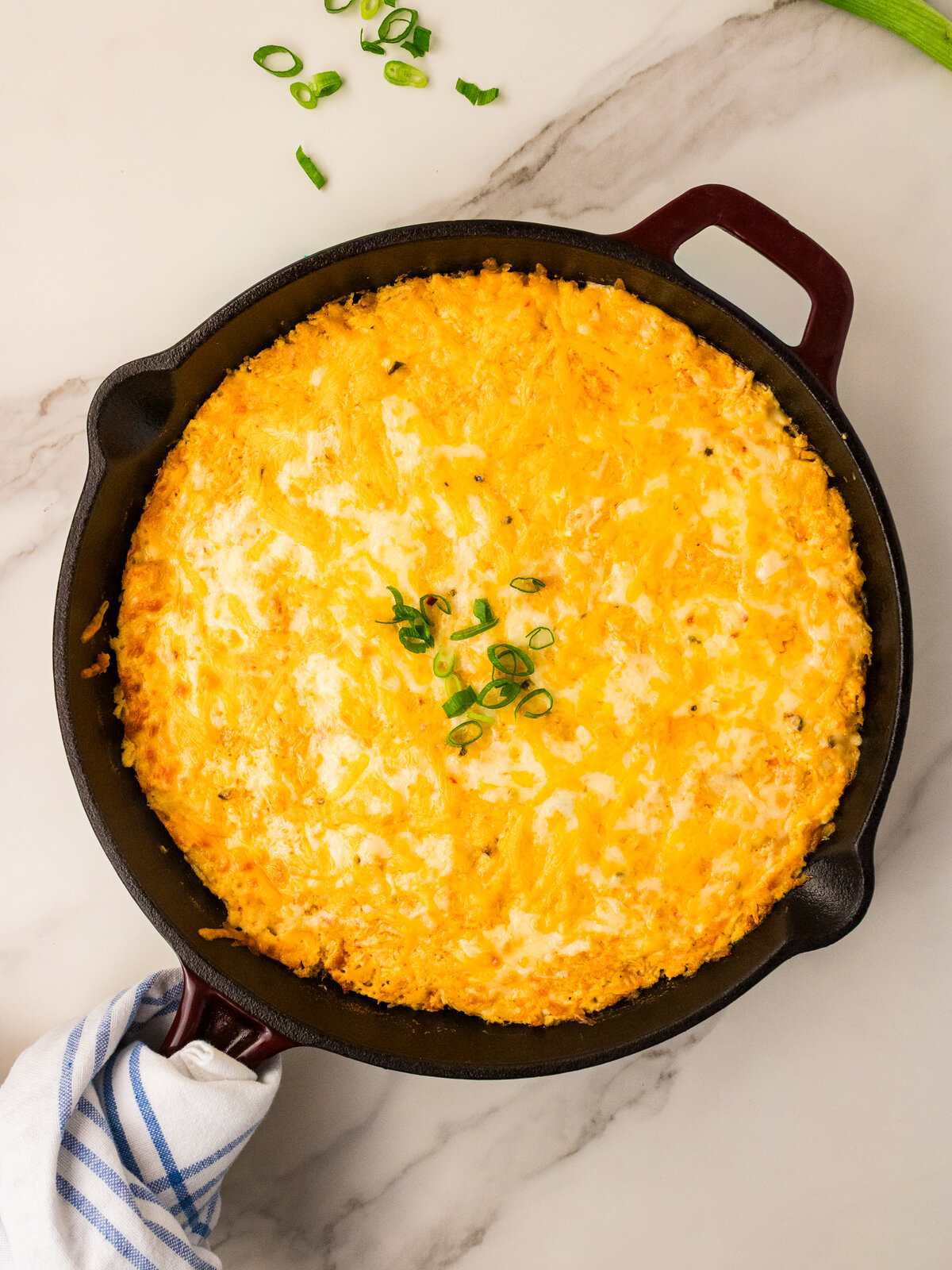 Baked buffalo chicken dip bubbling at the edges in a cast iron skillet