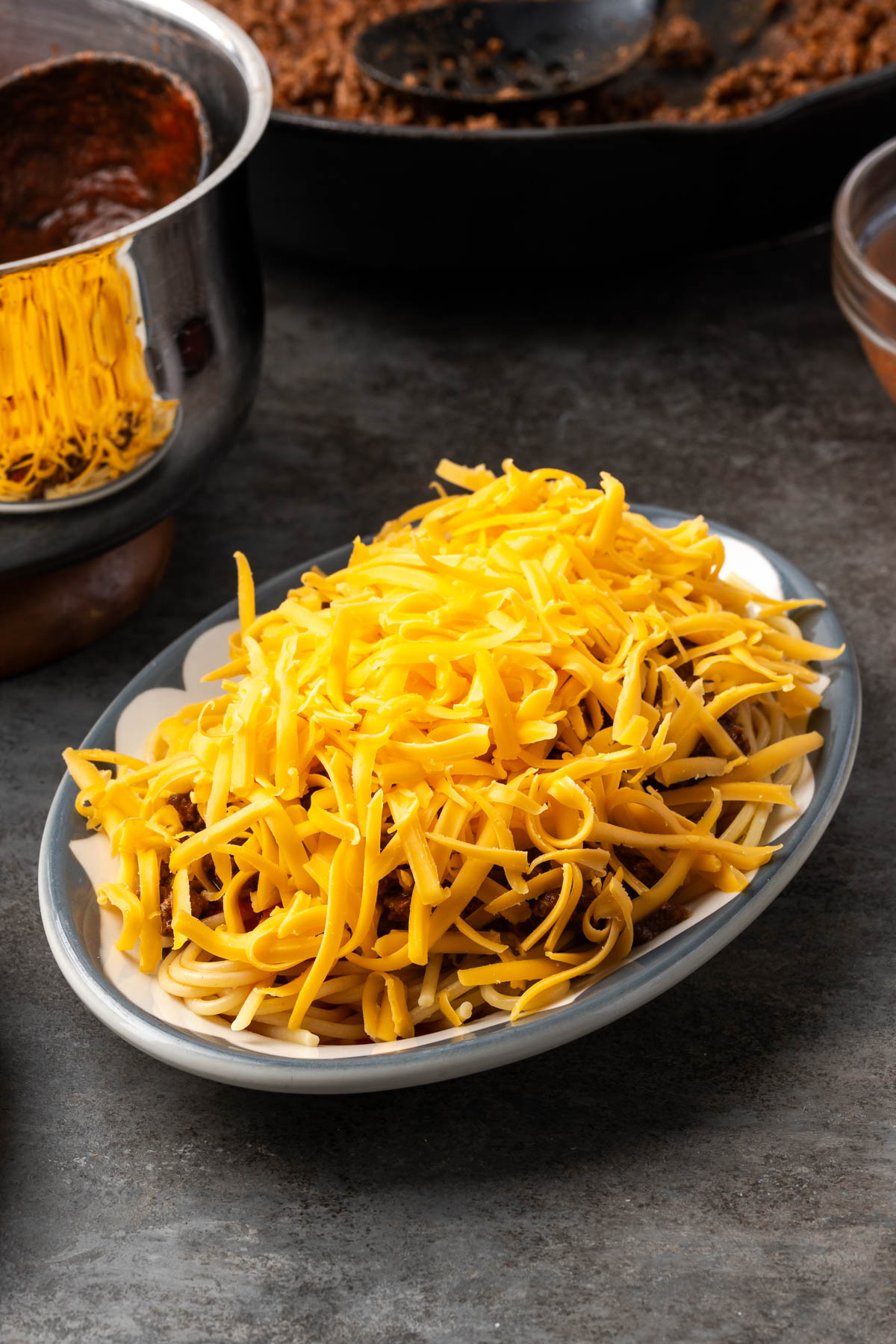 Shredded mild cheddar piled over the taco meat and sauce on the noodles
