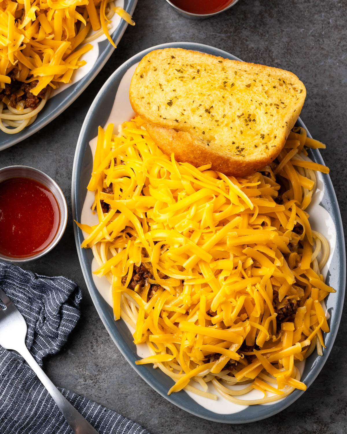 Overhead view of finished taco spaghetti with garlic bread and hot sauce