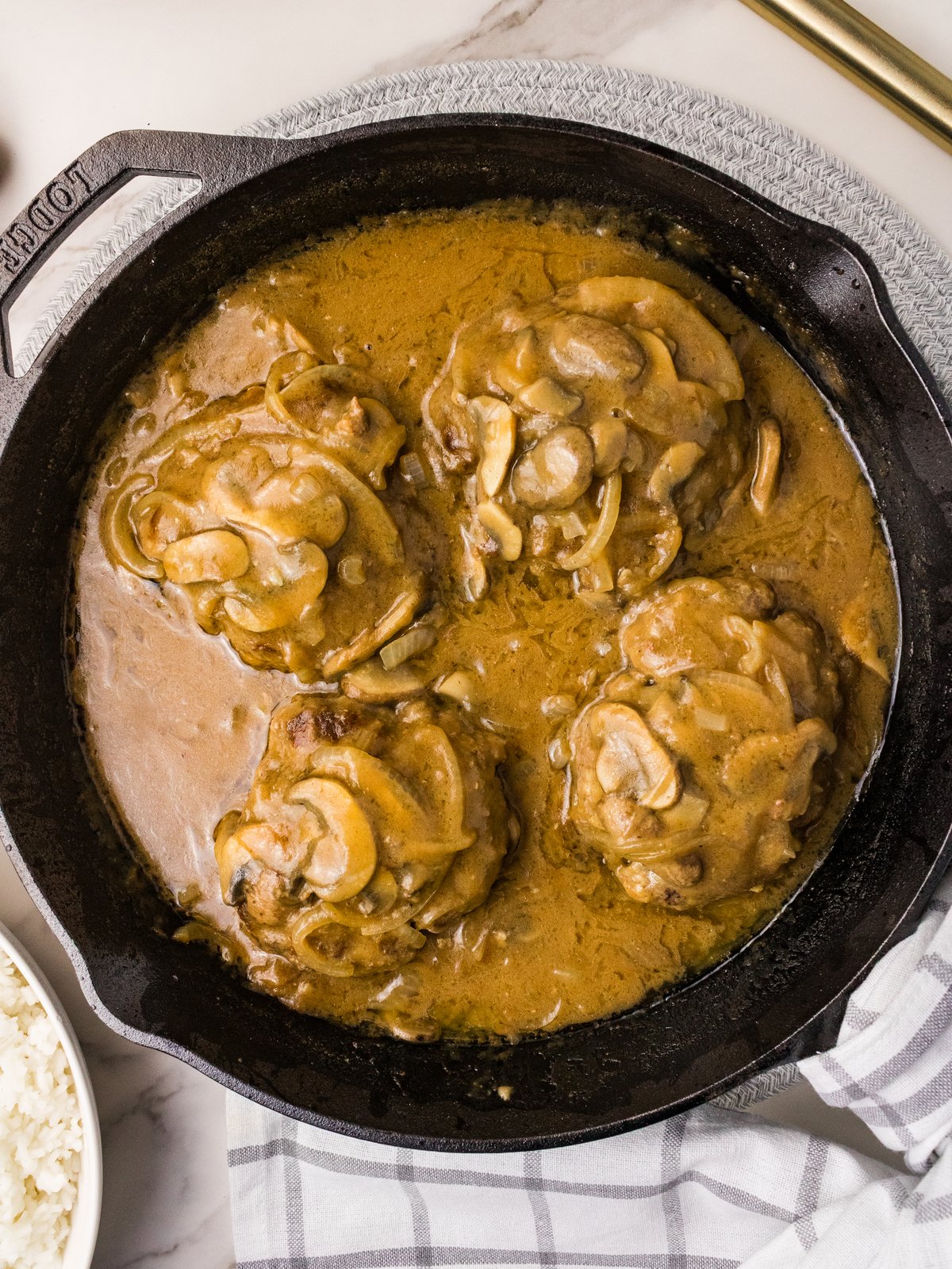 Cast iron skillet with hamburger steaks in mushroom gravy