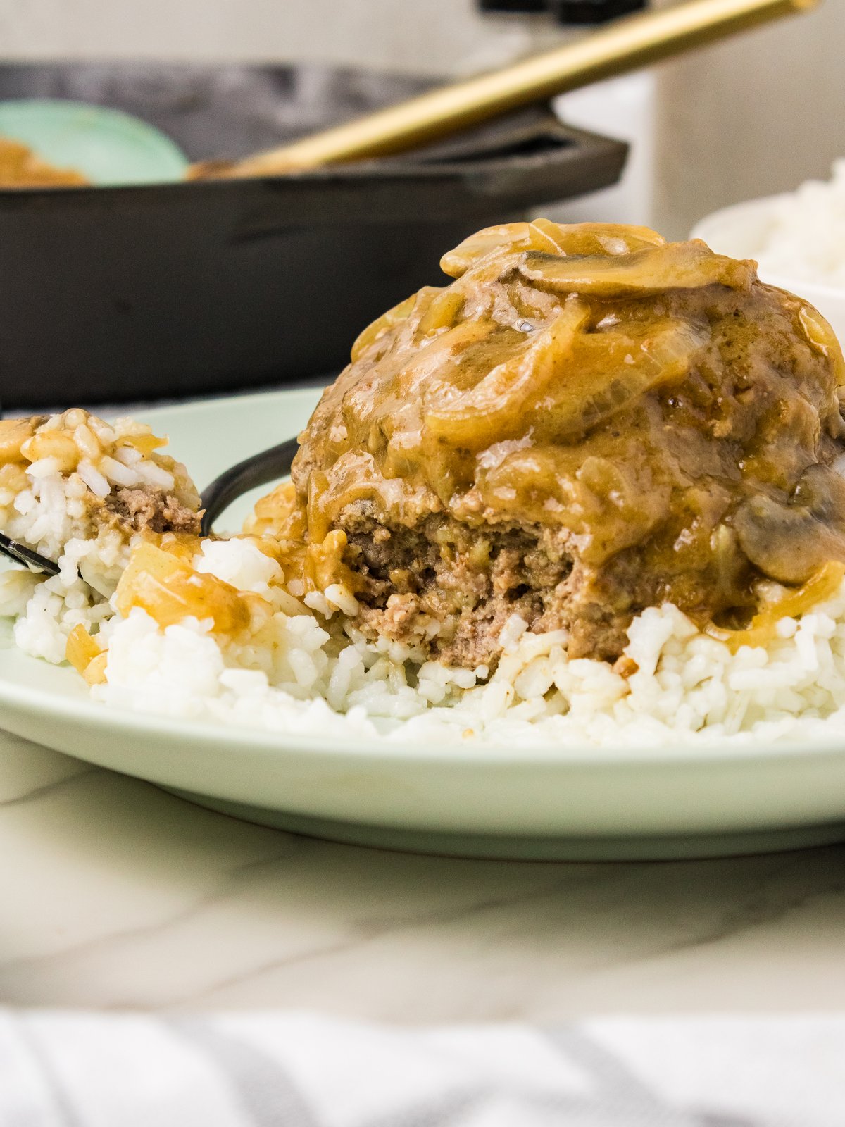 Plated hamburger steak with mushroom gravy over rice