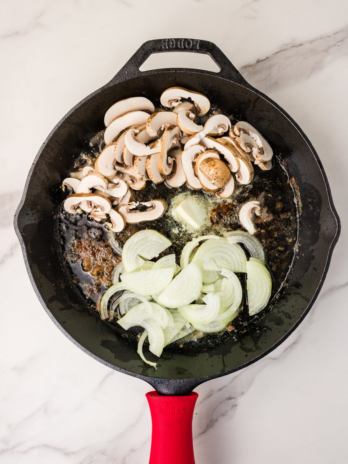 Mushrooms and onions sauteing in cast iron skillet