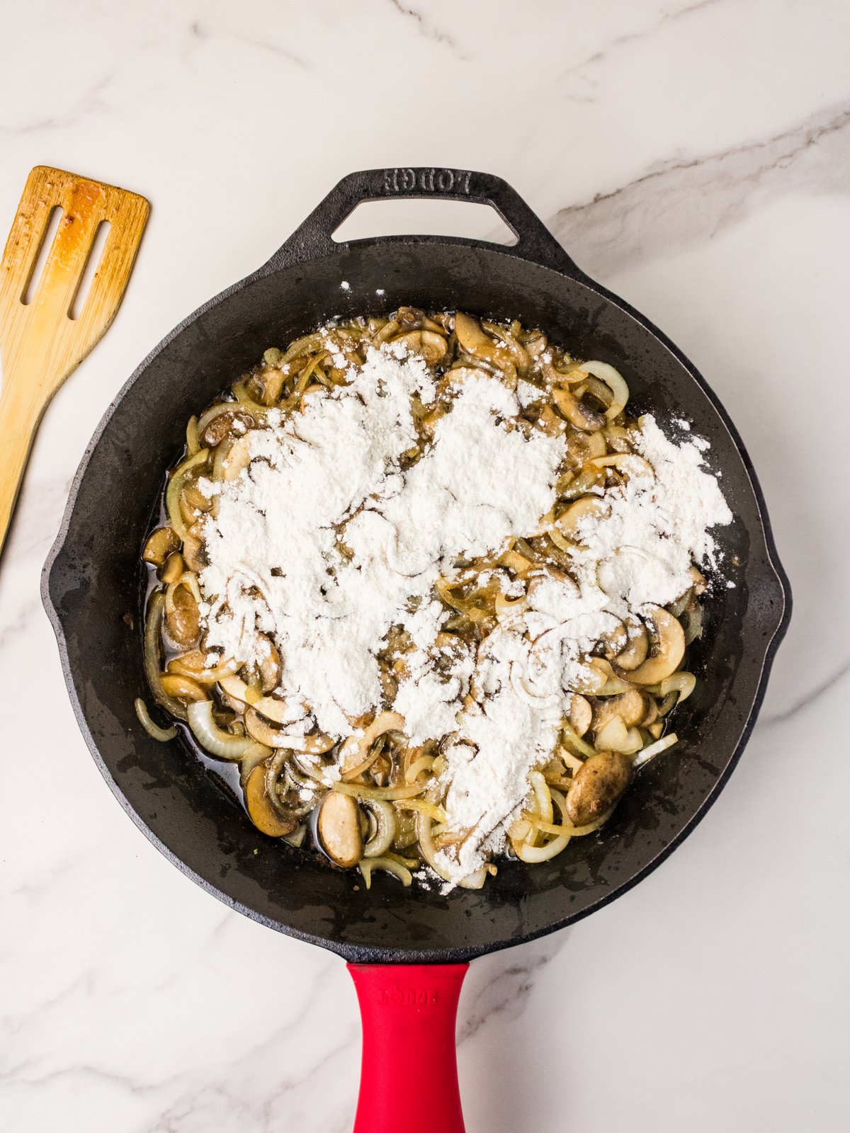 Adding flour to mushrooms and onions for gravy
