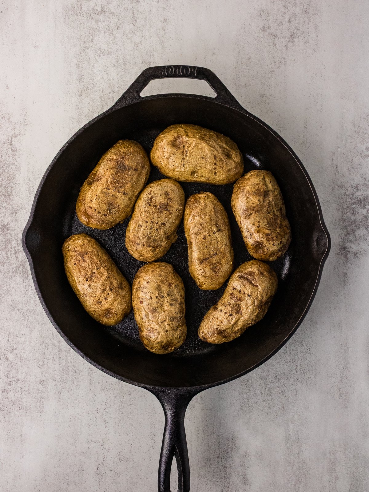 Baked russet potatoes arranged in a cast iron skillet
