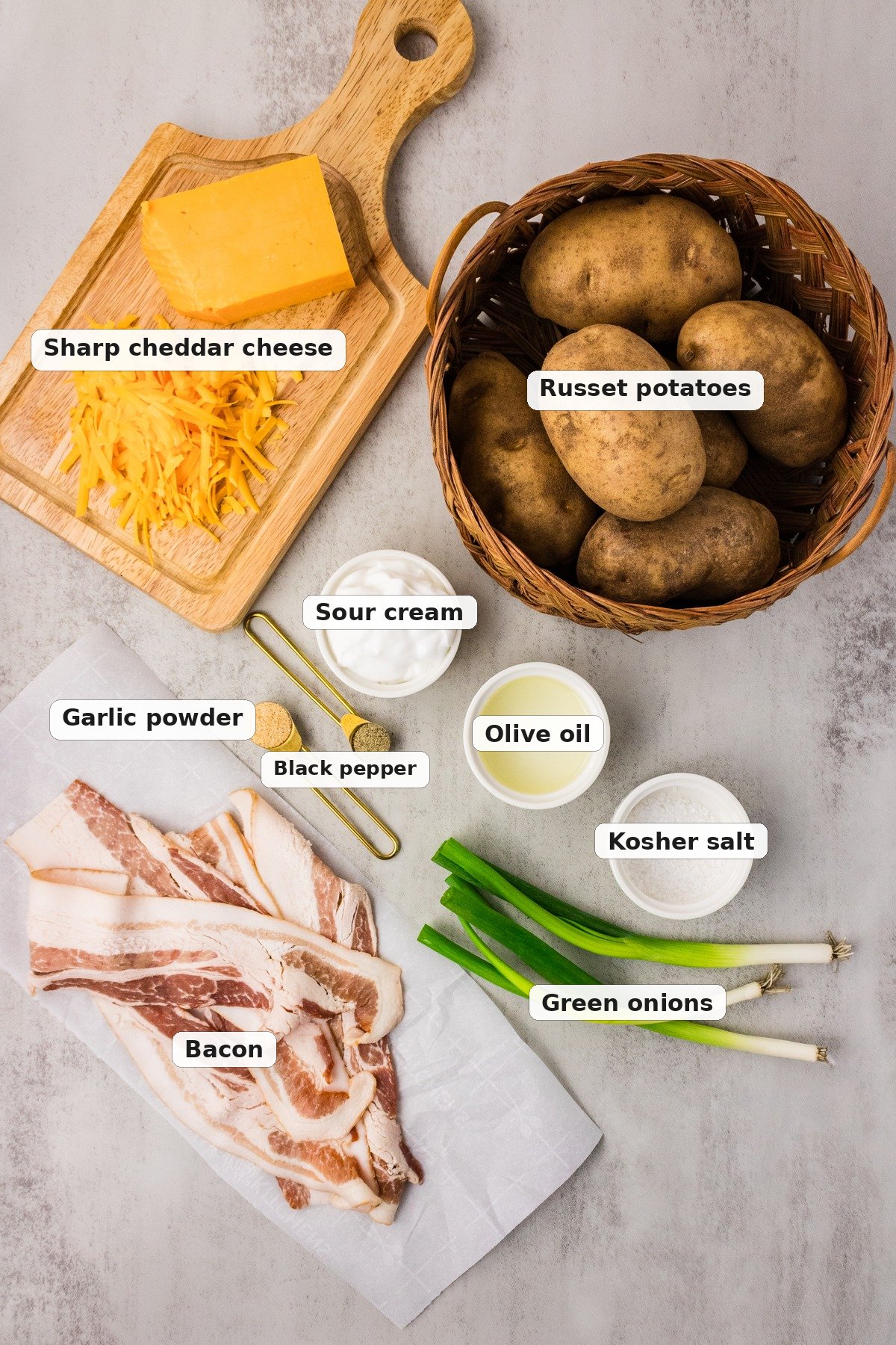 Ingredients for potato skins: russet potatoes, cheddar, bacon, sour cream, olive oil, kosher salt, garlic powder, black pepper and green onions